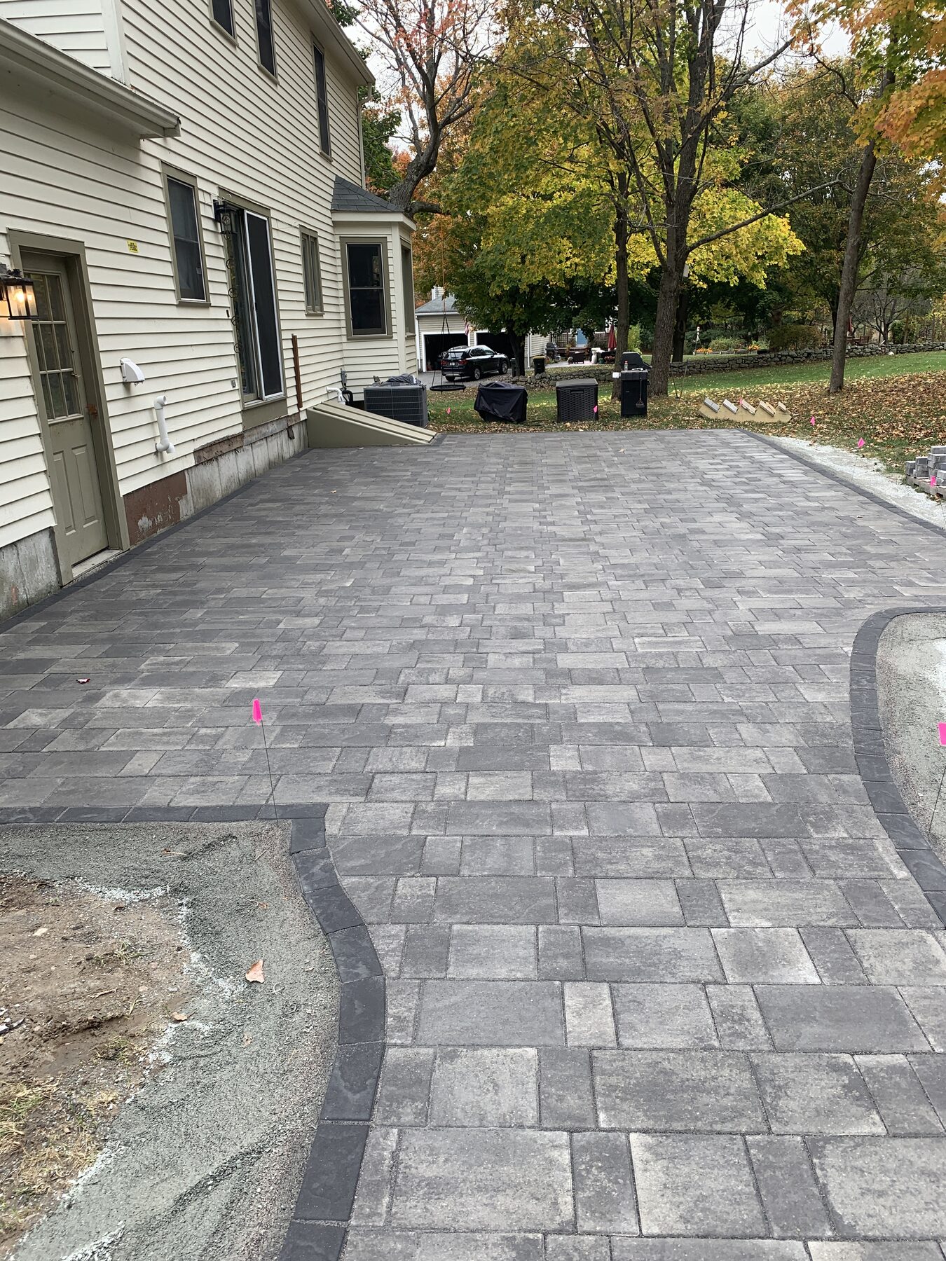 Finished concrete paver patio beside the house in Franklin Massachusetts