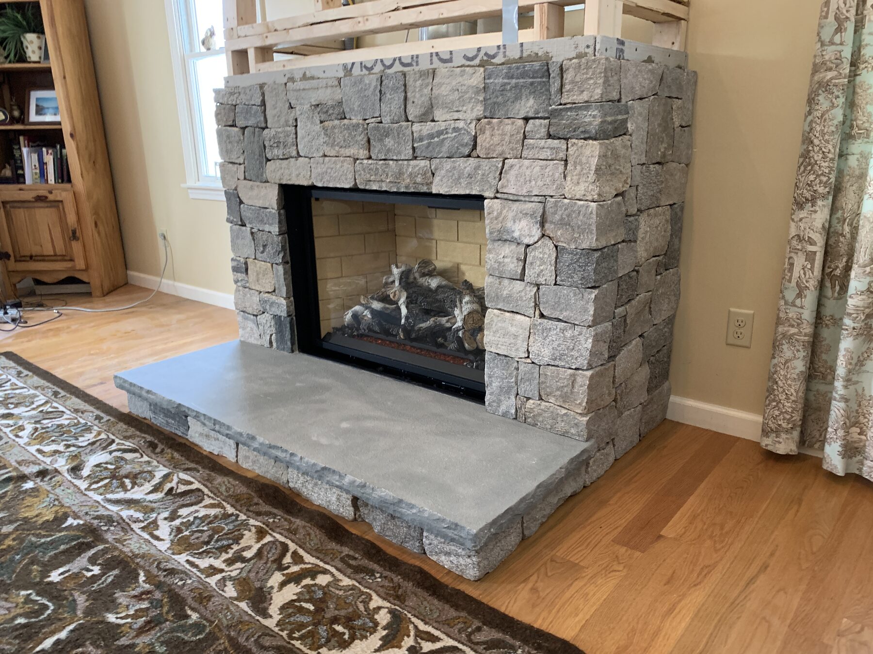 Stone veneer fireplace nearing completion